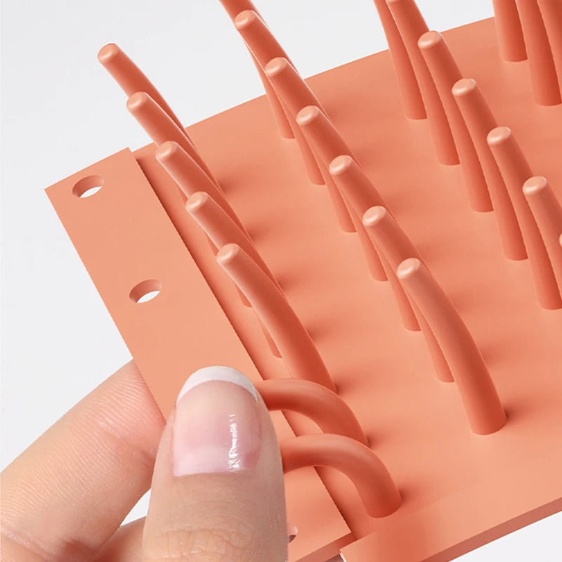 dog paw cleaner cup in green, orange and blue on clean modern background